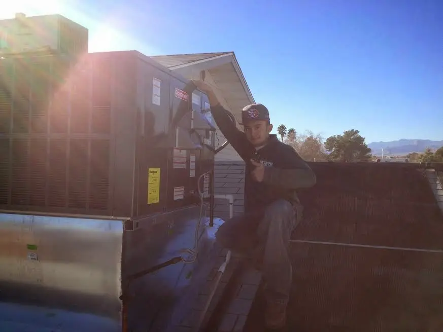 HVAC technician performing HVAC Inspection on a rooftop unit in Summit